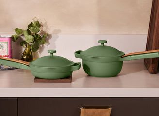 Two green cookware items on a kitchen counter with a neutral background