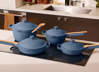 Set of blue cookware on a stove with a kitchen background