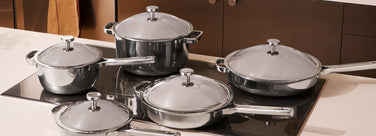 Set of titanium cookware on a stove with a kitchen background