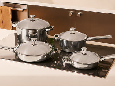 Set of titanium cookware with lids on a stove