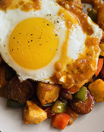 Fried egg on a bed of vegetables and potatoes