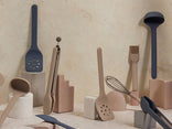 Set of kitchen utensils including spatulas, ladles, and whisks on a neutral background