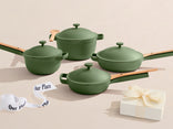 Set of green cookware with wooden handles on a beige surface, featuring 'Our Place' branding.