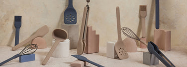 Set of silicone kitchen utensils on a neutral background