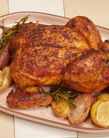 whole roasted chicken on a pink plate