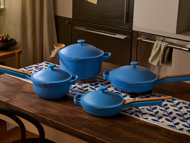 Set of blue cookware on a wooden table with kitchen background
