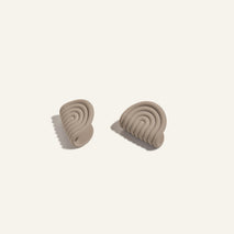 Pair of beige silicone pot holders  on a light beige background