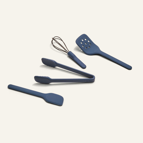 Mini Utensil Essentials—five compact, durable blue silicone tools (whisk, slotted spatula, tongs, two spatulas) arranged on a light background.