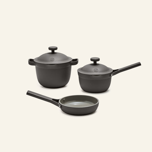 The Tiny Cookware Duo + Petite Perfect Pot, including a frying pan, a saucepan with lid, and a stockpot with lid in nonstick gray, are displayed on a plain light background.