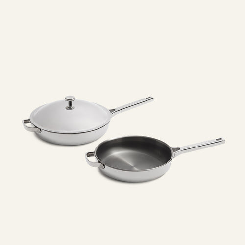 Two stainless steel pans from the Titanium Pro Always Pan Duo (2.0) set: one with a light-colored lid and one without.