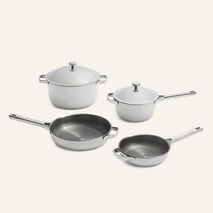 Titanium Pro Cookware Set (2.0) featuring four white-coated pots and pans with metal handles and two matching lids.