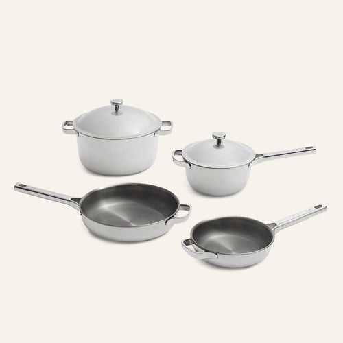 Titanium Pro Cookware Set (2.0) featuring four white-coated pots and pans with metal handles and two matching lids.