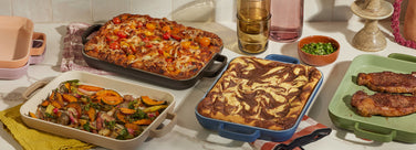Assorted baked dishes on a table with various serving dishes.