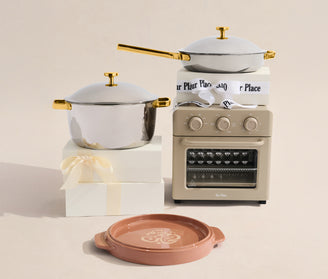 Set of cookware with a small oven on a beige background