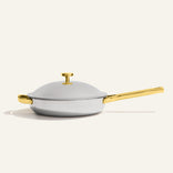 Titanium Always Pan Pro 32 cm (2.0) stainless steel pan with a matching lid, featuring gold-toned handles and a long gold-toned handle.