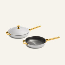 Titanium Pro Always Pan Duo (2.0) featuring two white stainless steel pans with gold-tone handles, one with a matching lid.