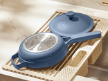 Blue cookware set on a kitchen rack with a marble countertop background