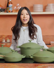 Woman in a kitchen with green cookware on a counter