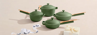 Set of green cookware with lids on a beige background