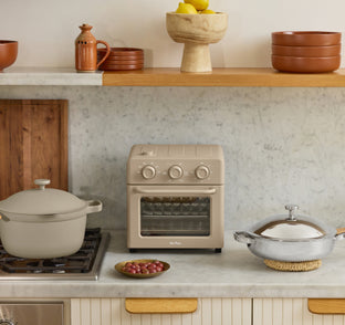 Kitchen setup with a stove, oven, and various kitchenware on a countertop.