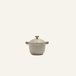 The Petite Perfect Pot, a beige nonstick pot with side handles, is shown centered on an off-white background—ideal for preparing non-toxic personal servings.