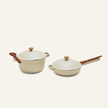 The Cookware Duo features two cream-colored bestsellers: a Dutch oven with a spoon rest handle and a deep skillet with a straight wooden handle—stylish essentials for your kitchen.